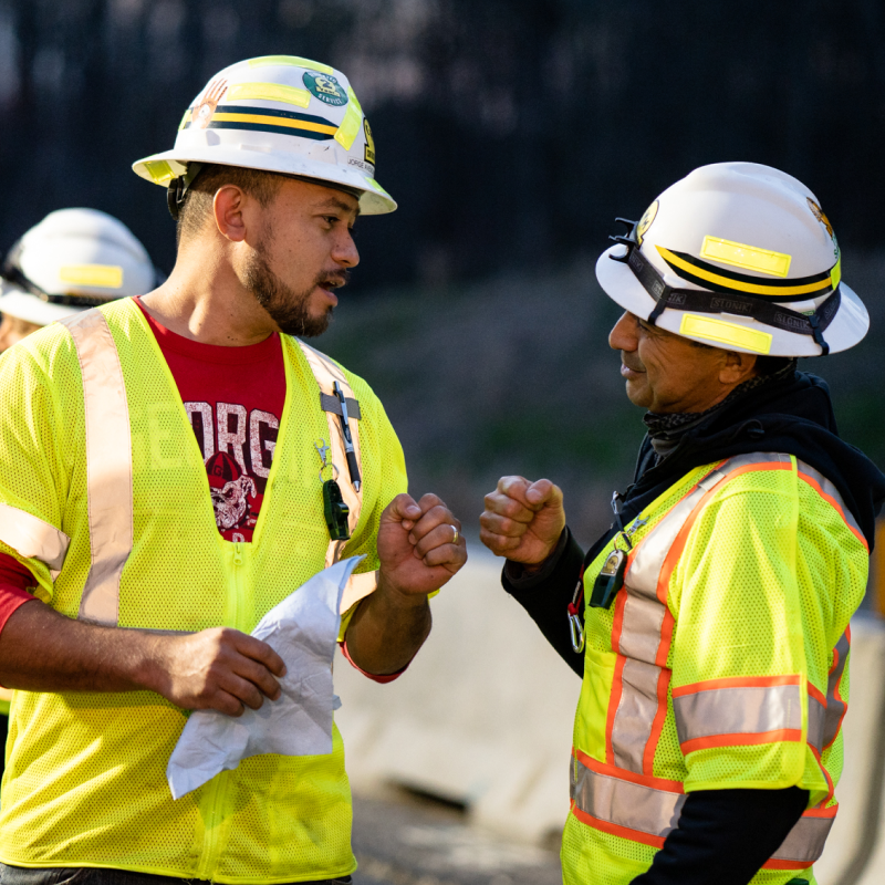 construction worker fist bumping on job site